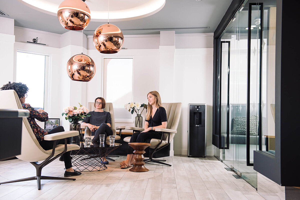 Modernes Büro mit Personen im Gespräch und Waterlogic Wasserspender