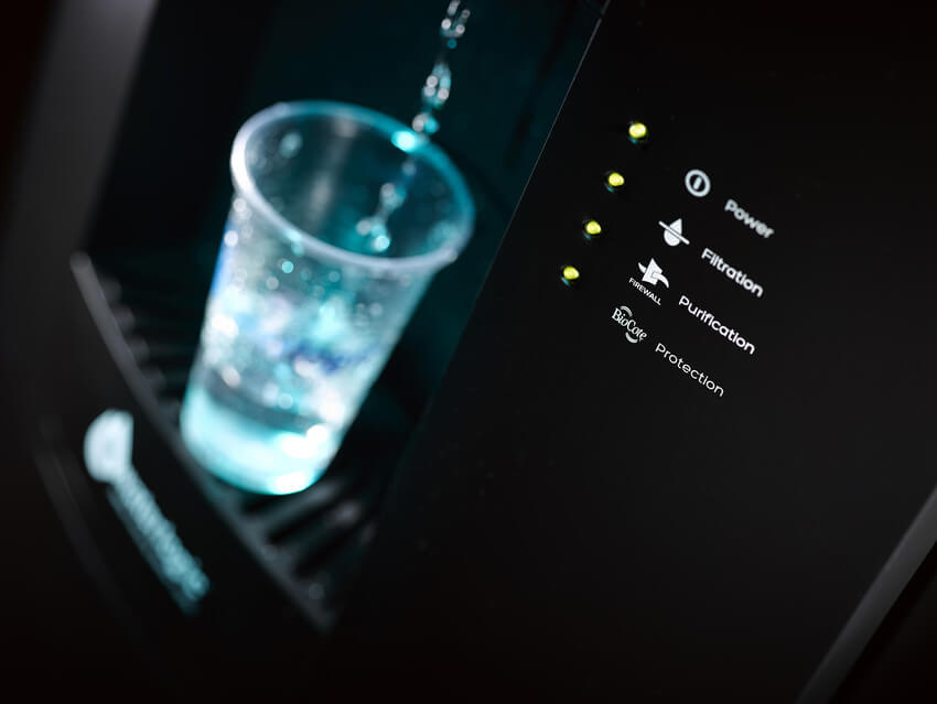 Plastikbecher welcher mit Wasser aus einem Waterlogic Wasserspender gefüllt wird