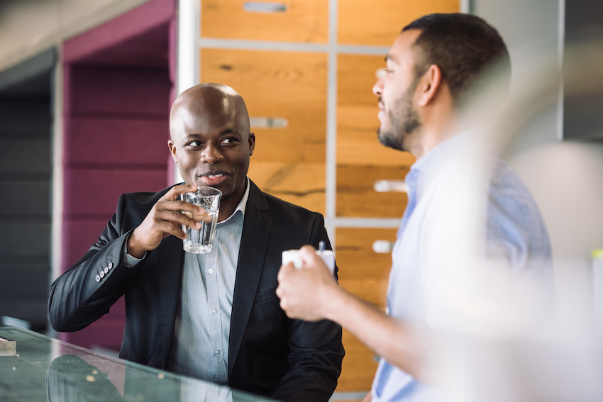 Zwei Männer unterhalten sich in einer modernen Büroküche 